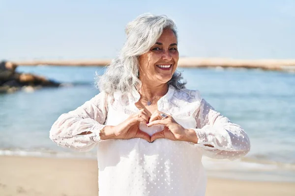 Middle Age Woman Smiling Confident Doing Heart Gesture Hands Seaside — Stock Photo, Image