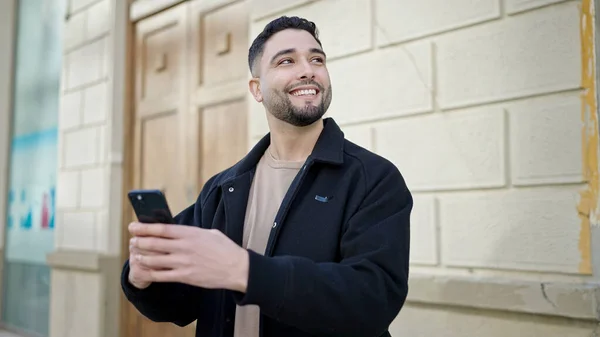 Fiatal Arab Férfi Mosolygós Magabiztos Segítségével Smartphone Utcán — Stock Fotó