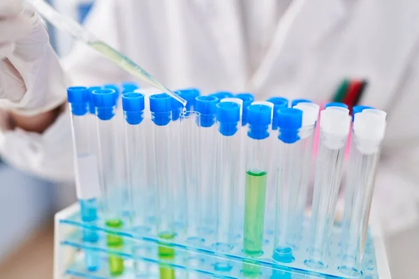 stock image Young woman scientist pouring liquid on test tubes at laboratory