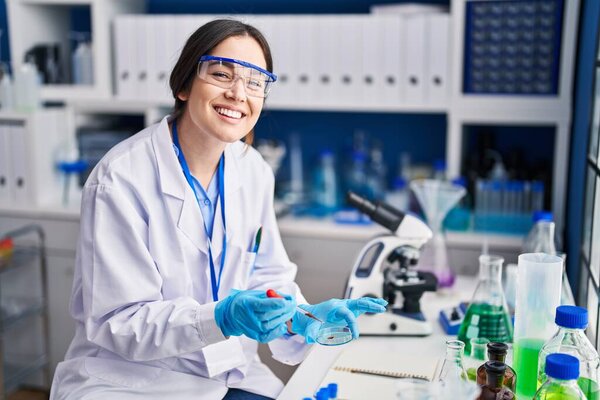 Young woman scientist analysing blood at laboratory