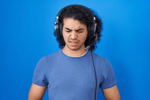 西班牙男人 用耳机听音乐 手放在肚子上 因为恶心 痛苦的疾病感觉不舒服 疼痛的概念 — 图库照片