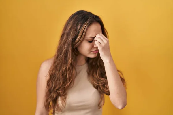 若いヒスパニック系の女性は黄色の背景に立って疲れ摩擦鼻や目の疲労や頭痛を感じている ストレスとフラストレーションの概念 — ストック写真
