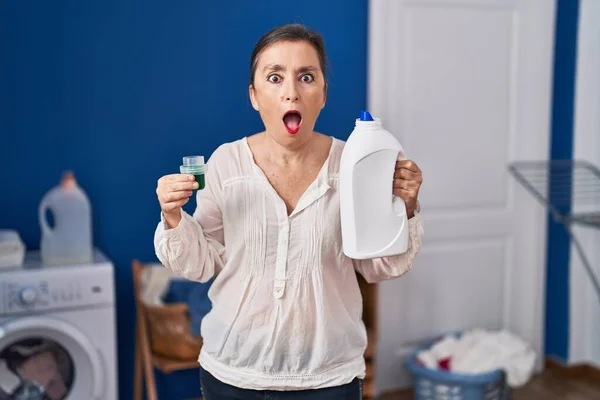 Middle Age Hispanic Woman Holding Detergent Bottle Afraid Shocked Surprise — Stock Photo, Image