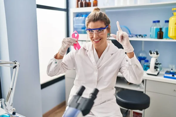 Молодая Женщина Работающая Научной Лаборатории Розовой Лентой Удивлена Идеей Вопросом — стоковое фото