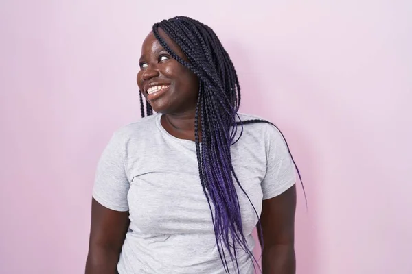 年轻的非洲女人站在粉红的背景上 面带微笑 表情自然地望向一旁 充满自信地大笑 — 图库照片