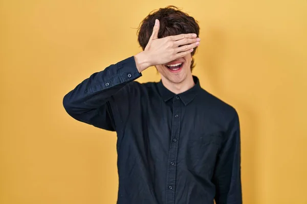 Mladý Muž Brýlemi Přes Žluté Pozadí Usmívá Rukama Tváři Zakrývá — Stock fotografie
