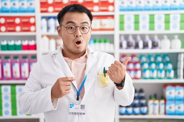 Jovem Chinês Trabalhando Farmácia Farmácia Farmácia Surpreso Apontando Com Dedo — Fotografia de Stock