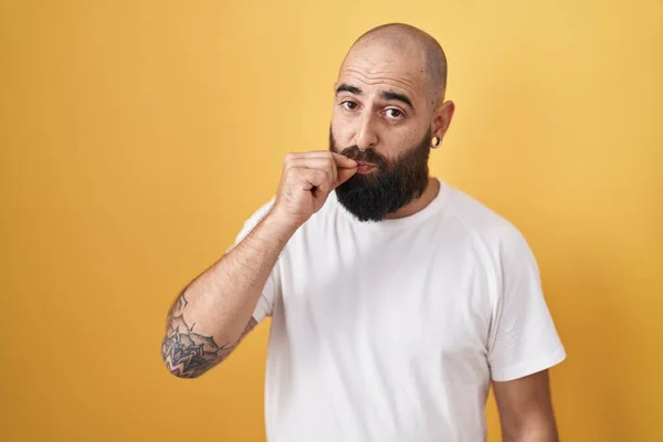 Junger Hispanischer Mann Mit Bart Und Tätowierungen Vor Gelbem Hintergrund — Stockfoto