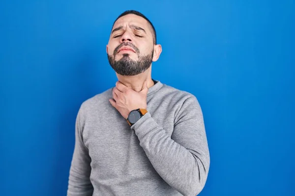 Hombre Hispano Pie Sobre Fondo Azul Tocando Doloroso Cuello Dolor —  Fotos de Stock
