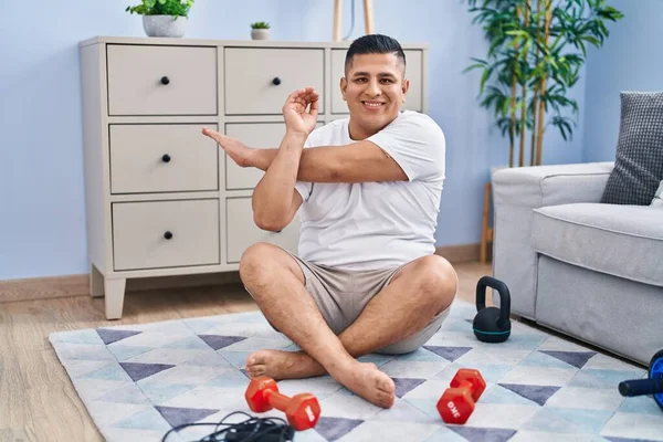 Jovem Latino Sorrindo Braço Alongamento Confiante Casa — Fotografia de Stock