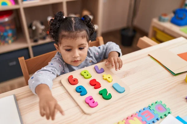 Adorable Hispanic Girl Playing Maths Puzzle Game Sitting Table Kindergarten — Stockfoto