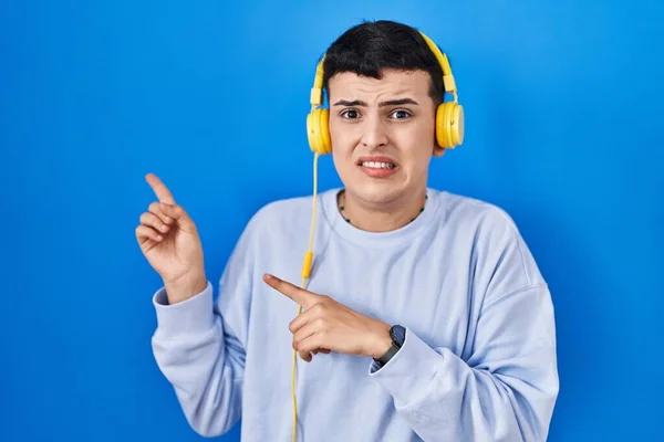 Persona Binaria Escuchando Música Usando Auriculares Apuntando Lado Preocupada Nerviosa — Foto de Stock