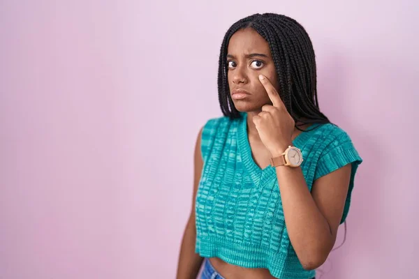 Молодой Африканский Американец Косичками Стоящий Розовом Фоне Указывая Глаз Наблюдая — стоковое фото