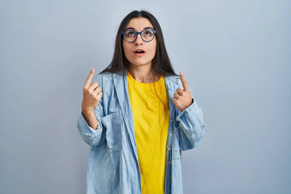 Young Hispanic Woman Standing Blue Background Amazed Surprised Looking Pointing — Stock Photo, Image