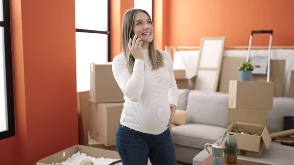 Молодая Беременная Женщина Разговаривает Смартфоне Касаясь Живота Новом Доме — стоковое фото