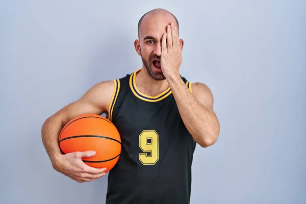 Mladý Plešatý Muž Vousy Basketbalové Uniformě Drží Míč Zakrývající Jedno — Stock fotografie