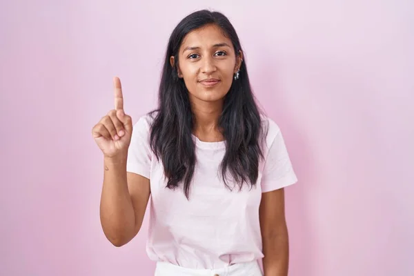Young Hispanic Woman Standing Pink Background Showing Pointing Finger Number — Stock Photo, Image