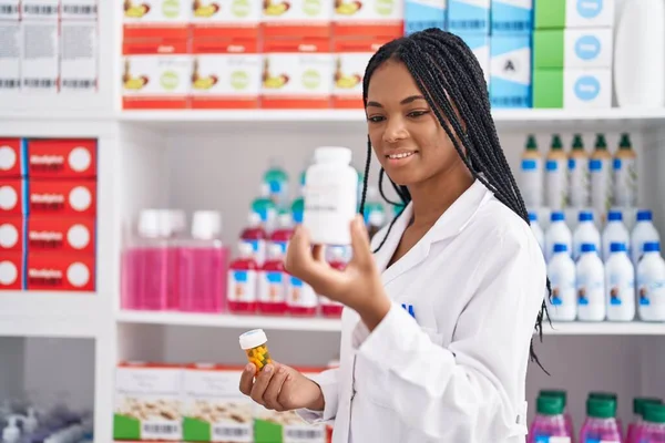 Afroamerikansk Kvinna Farmaceut Ler Säker Hålla Piller Flaskor Apoteket — Stockfoto