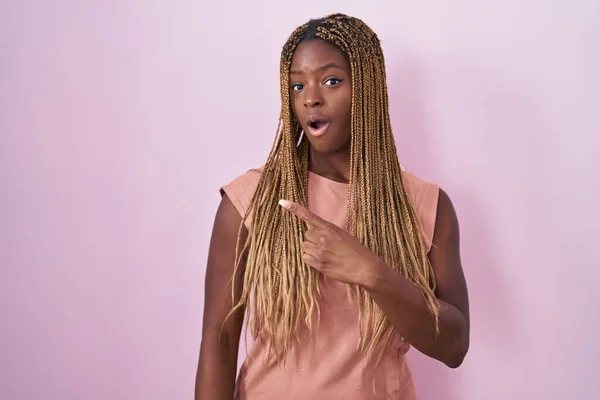Африканская Американка Плетеными Волосами Стоя Розовом Фоне Удивлен Указывая Пальцем — стоковое фото