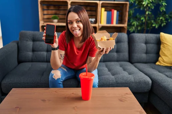 Young Hispanic Woman Eating Fast Food Showing Smartphone Screen Sticking — Stock Photo, Image