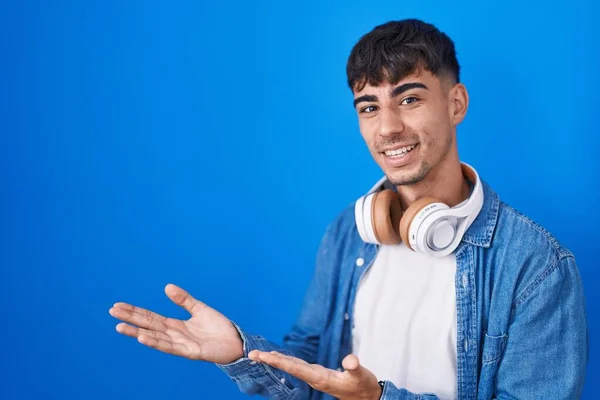 Mavi Arka Planda Duran Spanyol Genç Adam Gülümseyerek Doğal Bir — Stok fotoğraf