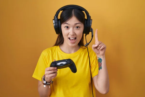 Jovem Chinesa Jogando Vídeo Game Segurando Controlador Apontando Dedo Para — Fotografia de Stock