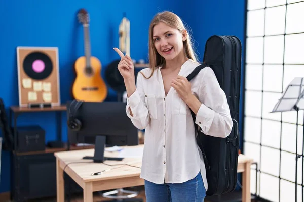 Joven Mujer Caucásica Sosteniendo Estuche Guitarra Sonriendo Feliz Señalando Con —  Fotos de Stock