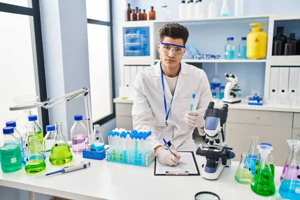 Jovem Hispânico Vestindo Uniforme Cientista Escrevendo Área Transferência Laboratório — Fotografia de Stock