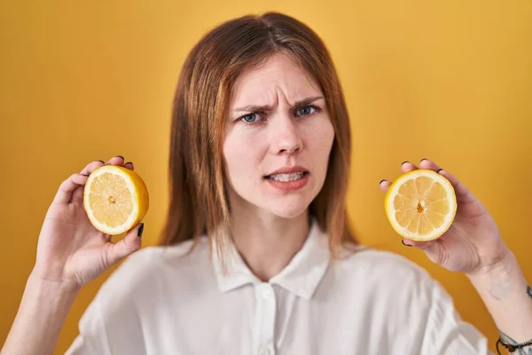 Schöne Frau Mit Zitronen Ahnungslosen Und Verwirrten Gesichtsausdruck Zweifelhaftes Konzept — Stockfoto