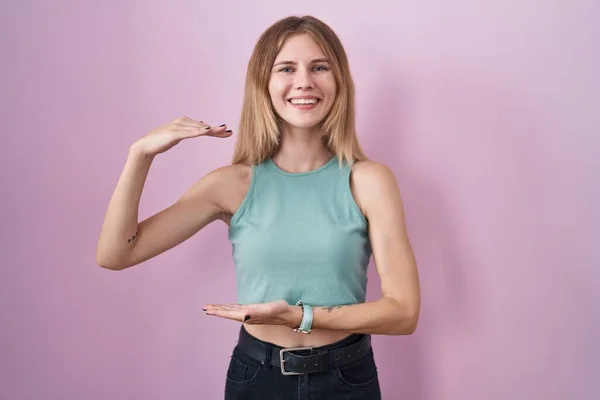 Blonde Caucasian Woman Standing Pink Background Gesturing Hands Showing Big — Stockfoto