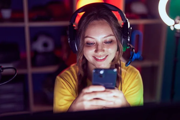 年轻的金发女子在游戏室用电脑和智能手机流口水 — 图库照片