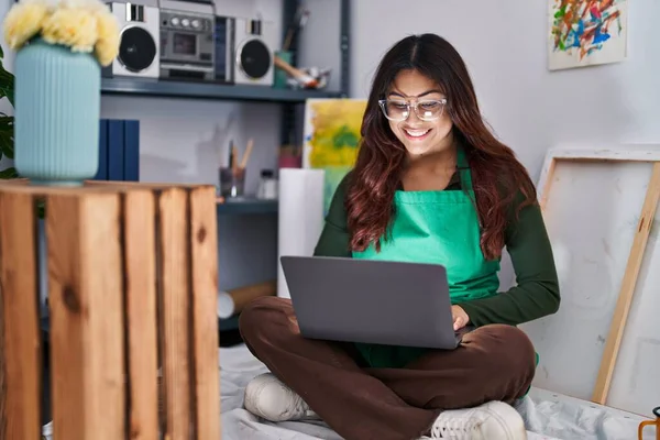 Young Hispanic Woman Artist Using Laptop Sitting Floor Art Studio — Foto de Stock