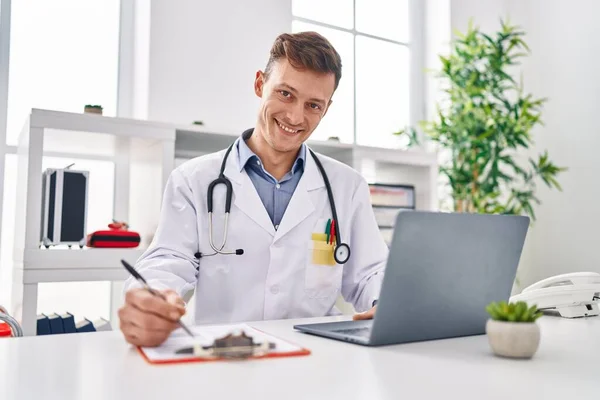 Young Man Doctor Using Laptop Writing Clipboard Clinic — Stok fotoğraf