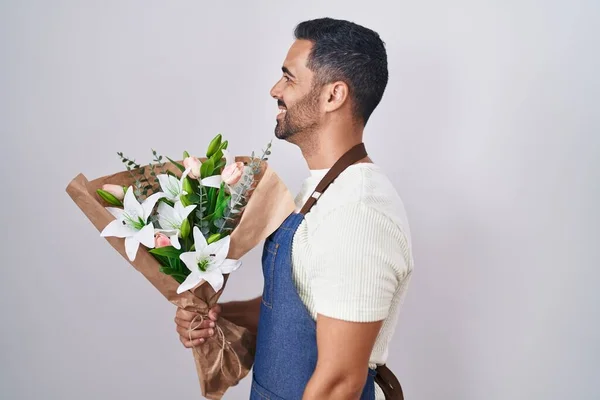 Hispanic man with beard working as florist looking to side, relax profile pose with natural face and confident smile.