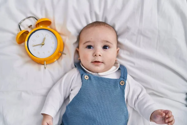 Adorable Baby Lying Bed Next Alarm Clock Bedroom — Stock Photo, Image