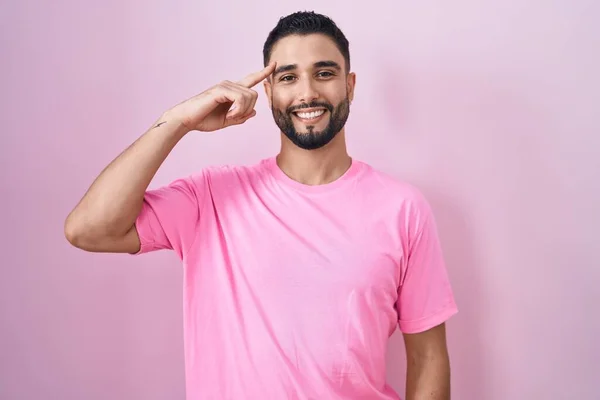 Spaanse Jongeman Staat Roze Achtergrond Glimlachend Wijzend Naar Het Hoofd — Stockfoto