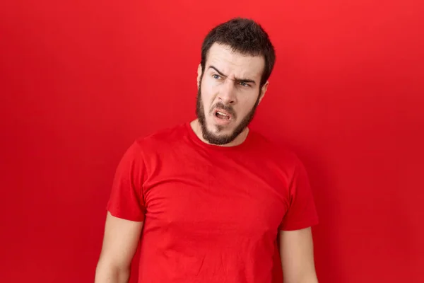 Jonge Spaanse Man Draagt Casual Rood Shirt Shock Gezicht Zoek — Stockfoto
