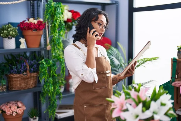 Young Beautiful Hispanic Woman Florist Talking Smartphone Reading Clipboard Flower — Stockfoto