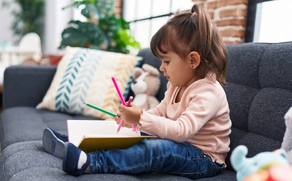Adorable Hispanic Girl Drawing Notebook Sitting Sofa Home — Stockfoto
