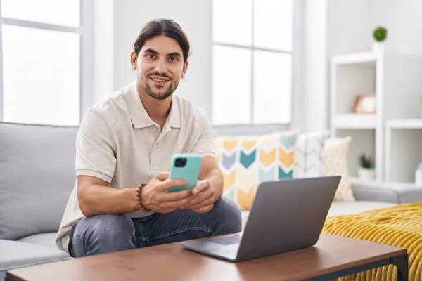 Young Hispanic Man Using Laptop Smartphone Sitting Sofa Home — Stock Photo, Image