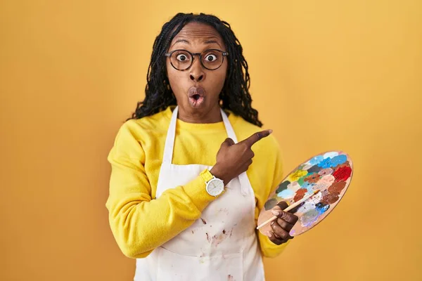 Mujer Africana Sosteniendo Paleta Pintores Sorprendida Señalando Con Dedo Hacia —  Fotos de Stock