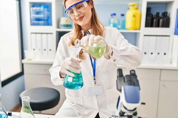 Young Blonde Woman Wearing Scientist Uniform Pouring Liquid Test Tube — Stock Photo, Image