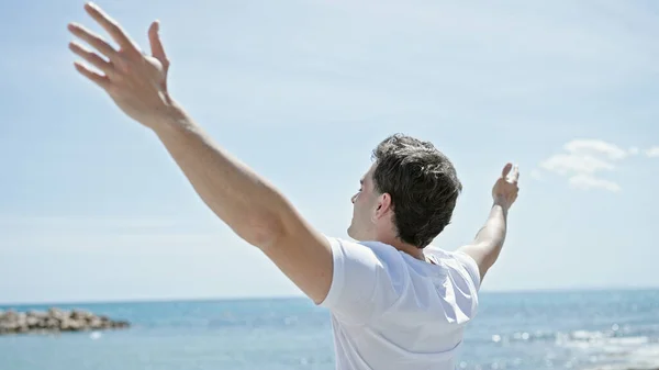 年轻的惊慌失措的男子张开双臂在海滩上呼吸 — 图库照片