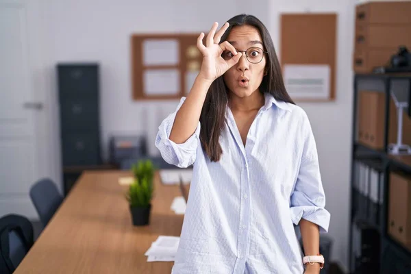 オフィスで若いヒスパニック系の女性の をジェスチャーを行う驚きの顔で 目の指を見てショックを受けた 信じられない表現 — ストック写真
