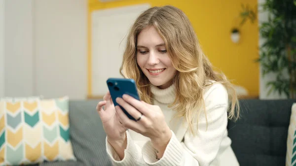 Jong Blond Vrouw Met Behulp Van Smartphone Zitten Bank Thuis — Stockfoto