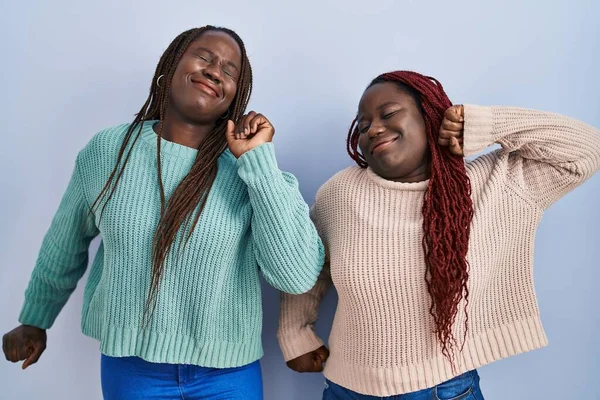 Dos Mujeres Africanas Pie Sobre Fondo Azul Estirándose Hacia Atrás —  Fotos de Stock