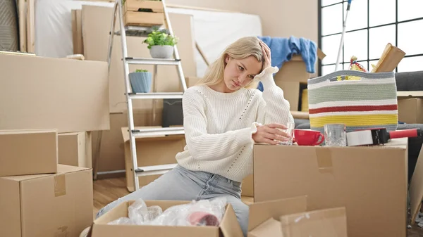 Young Blonde Woman Unpacking Cardboard Box Stressed New Home — ストック写真