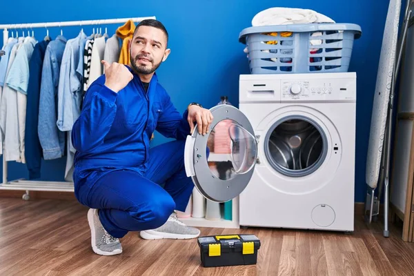 Reparador Hispânico Trabalhando Máquina Lavar Apontando Polegar Até Lado Sorrindo — Fotografia de Stock