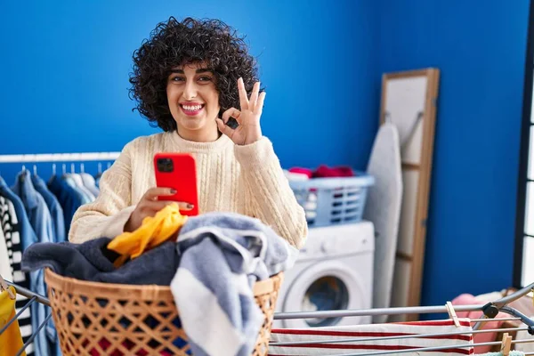 Genç Esmer Kıvırcık Saçlı Çamaşır Yıkayan Akıllı Telefon Kullanan Parmaklarıyla — Stok fotoğraf
