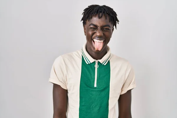 ドレッドロックを持つアフリカの男は 面白い表現で幸せ舌を突き出して孤立した背景の上に立っている 感情の概念 — ストック写真